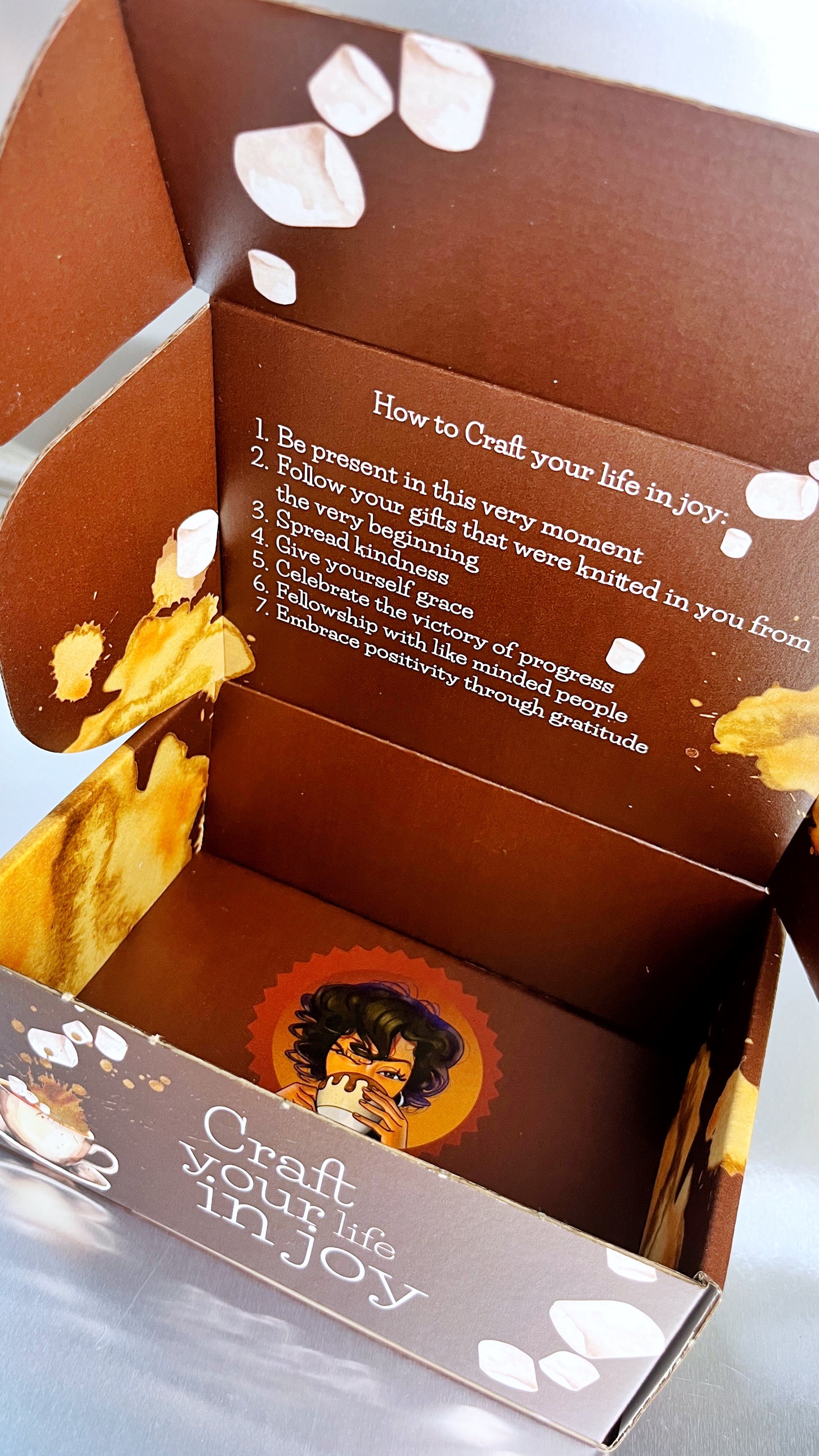 Inside of the box for the hot chocolate experience with the logo of chef farrell drinking cocoa and the words craft your life in joy on the outside