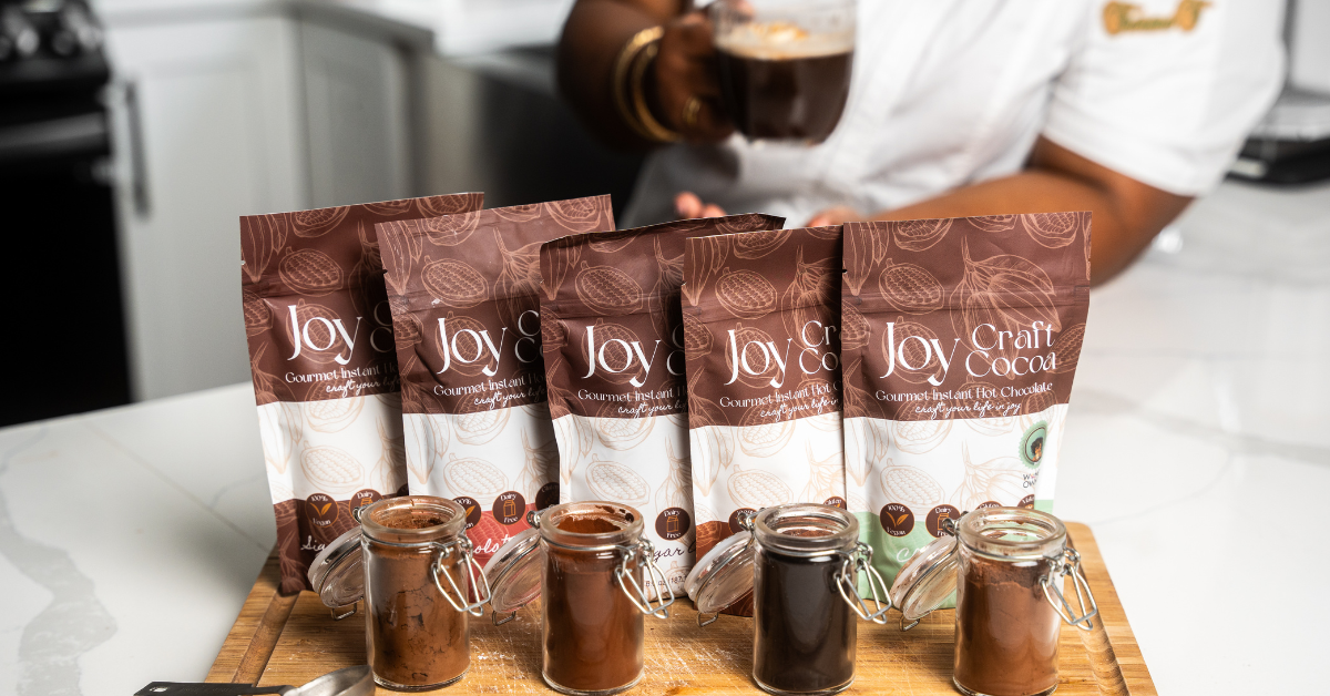 photo of a cutting board with 4 different flavors of hot chocolate with different colored cocoas in front